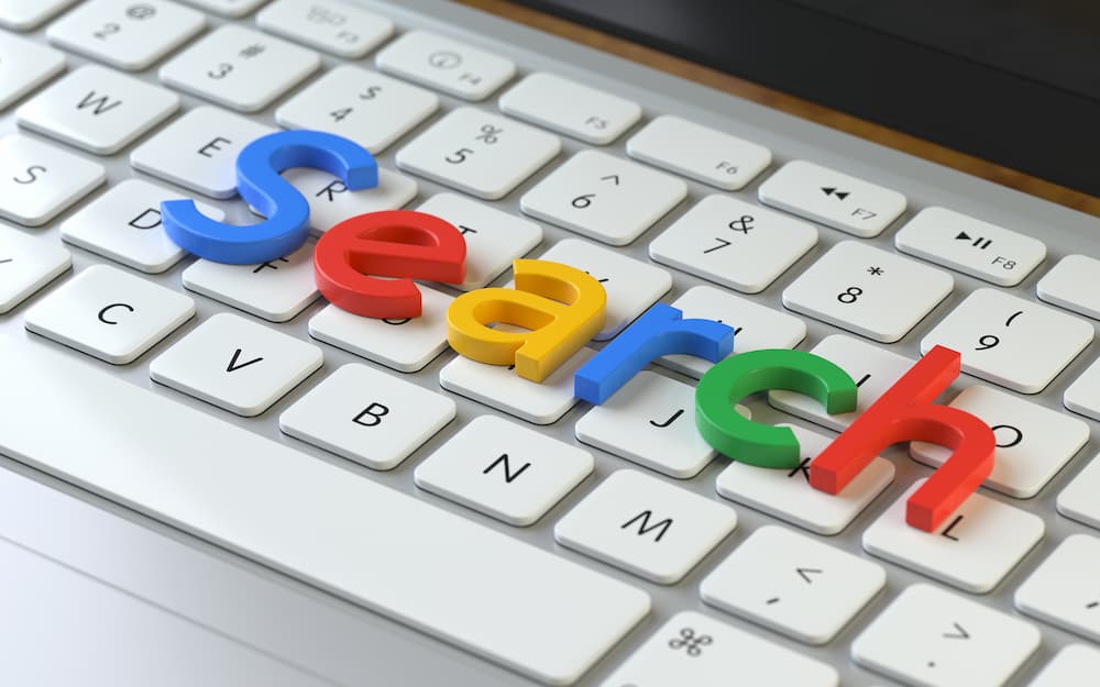 Tastatur mit Bauklötzchen-Buchstaben in Google-Farben, die das Wort 'Search' formen