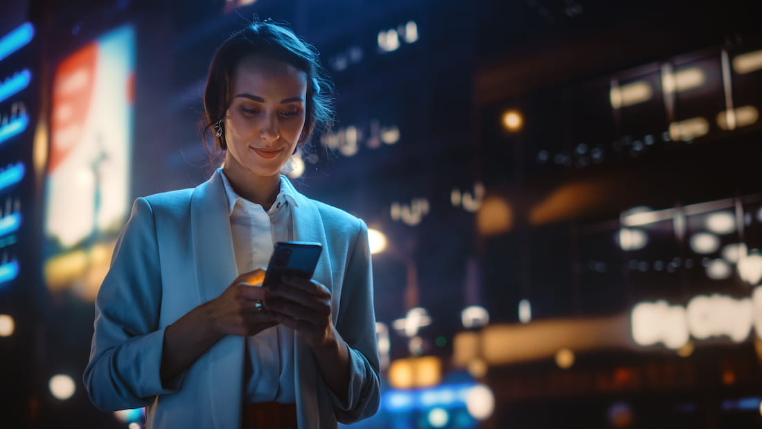 Woman using her smartphone, symbolizing remarketing in hotel marketing