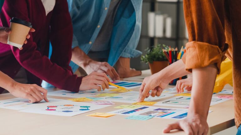 Team bei der Arbeit an der Planung und Entwicklung von Marketingstrategien mit Notizen und Diagrammen auf einem Tisch