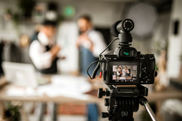 A camera focuses on two people in a studio being recorded for a social media video - perfect visualization of content creation for hotels.