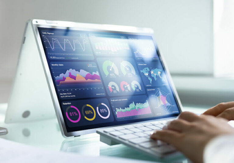 Person using a laptop with graphical dashboards to monitor social media ads and marketing analytics.